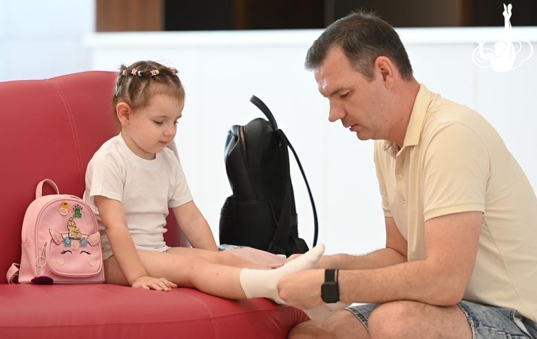 A young gymnast with her father before selection start