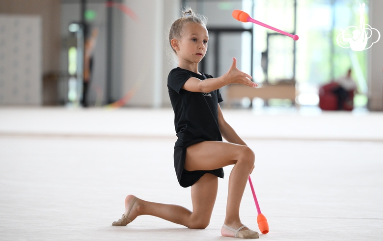 Young gymnast performing a club routine