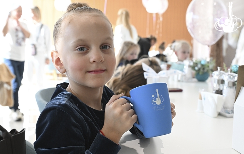 A young gymnast with a gift during the celebration at the Academy