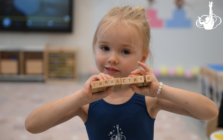 Юная гимнастка во время занятия, посвященного истории художественной гимнастики