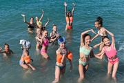 Young gymnasts swim in the sea after training on the beach