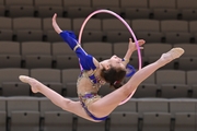 Karolina Tarasova does a split jump during an exercise with a hoop