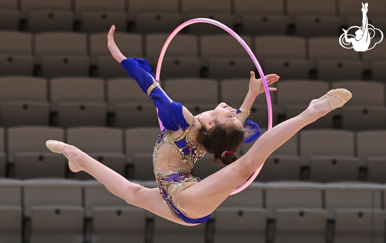 Karolina Tarasova does a split jump during an exercise with a hoop