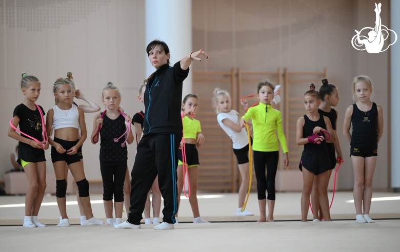 Coach Olesya Kovaleva with gymnasts during practice at the training camp in the Academy