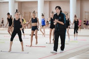 Coach Olesya Kovaleva with gymnasts during practice at the training camp in the Academy