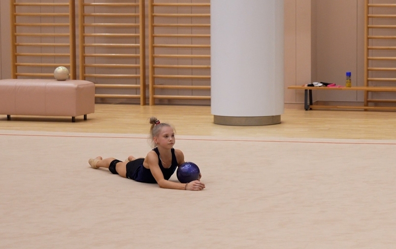 Alina Kabaeva demonstrates Eva Kononova how to work with ball on the floor