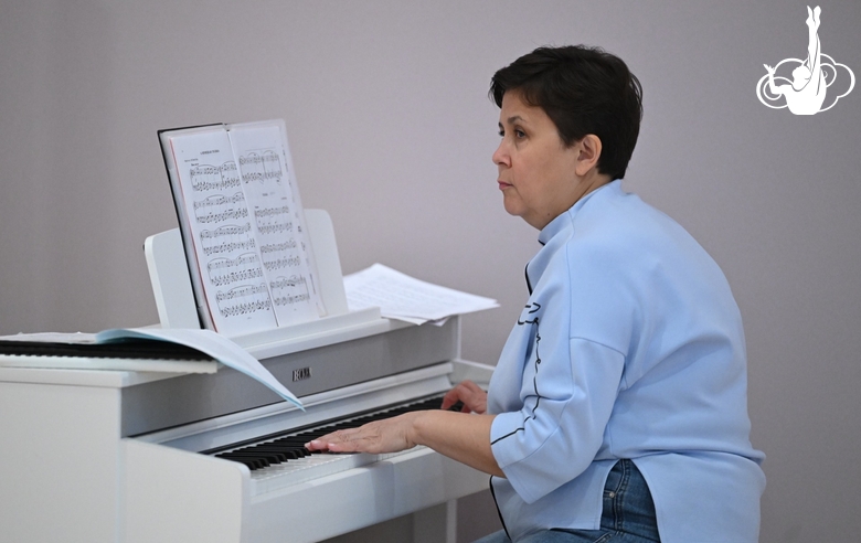 Концертмейстер во время занятия дошкольниц ритмикой