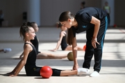 Coach Ekaterina Lots with gymnasts during practice at the training camp in the Academy