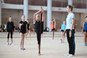 Coach Olga Frolova with gymnasts during practice at the training camp in the Academy