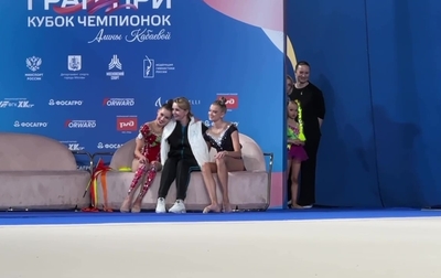 Masha Borisova, Sasha Borisova and their coach Irina Gusarova in the kiss-and-cry area