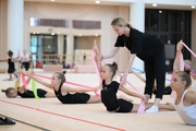 A gymnast with a coach during the training session