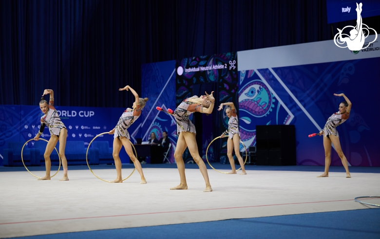 Group gymnasts during an exercise with hoops and clubs