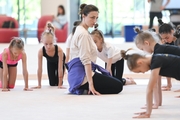 Coach Irina Dzyuba with young gymnasts during a training session