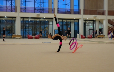 Яна Заикина отрабатывает упражнение с лентой вместе с олимпийской чемпионкой Алиной Кабаевой