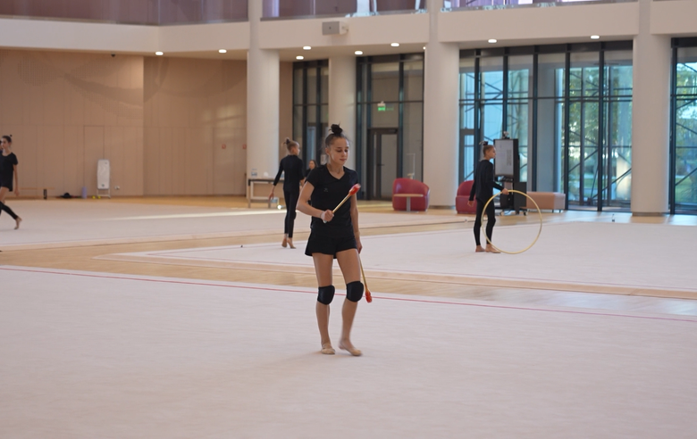 Olympic champion Alina Kabaeva and coach Irina Gusarova explain to Mariia Borisova why it's important to go all the way