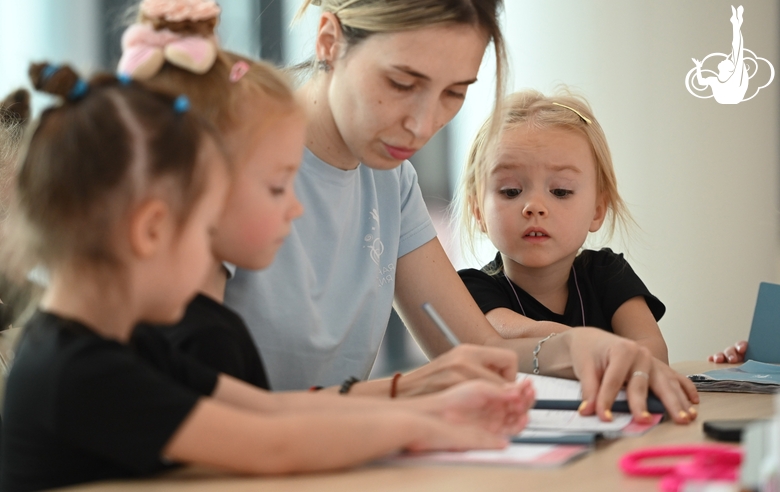 Academy coach Olga Frolova with young gymnasts during class  Young gymnasts during training