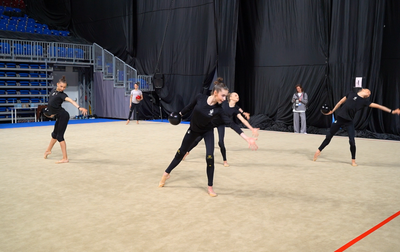 The Olympic champion helps group exercise gymnasts of the Academy to work on the tempo in the balls routine on the verge of the event