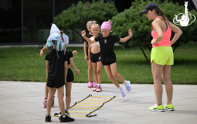 Academy coach Olesya Kovaleva and young gymnasts during training