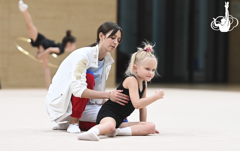 Academy coach Elizaveta Chernova with a young gymnast