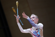 A gymnast performs an element with clubs during an assessment training