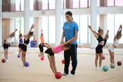 Coach Ekaterina Lots with gymnasts during practice at the training camp in the Academy