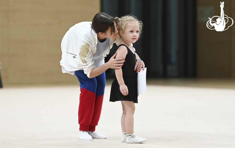 Academy coach Elizaveta Chernova with a young gymnast