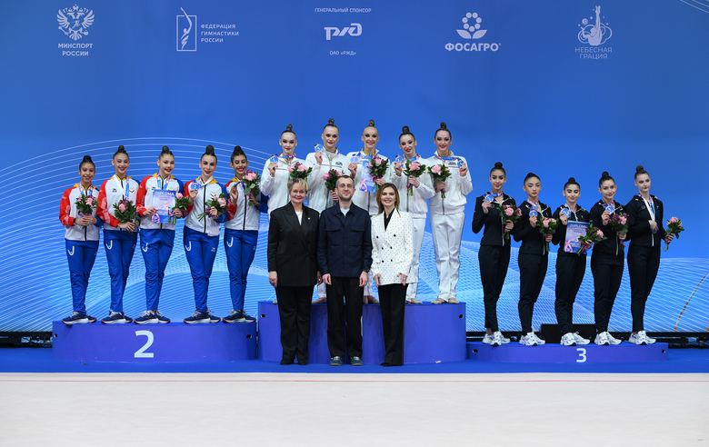 16 марта 2026 года. Олимпийская чемпионка Алина Кабаева, вице-губернатор Санкт-Петербурга Борис Пиотровский и главный судья турнира, член технического комитета Международной федерации гимнастики Наталья Буланова во время церемонии награждения групповичек