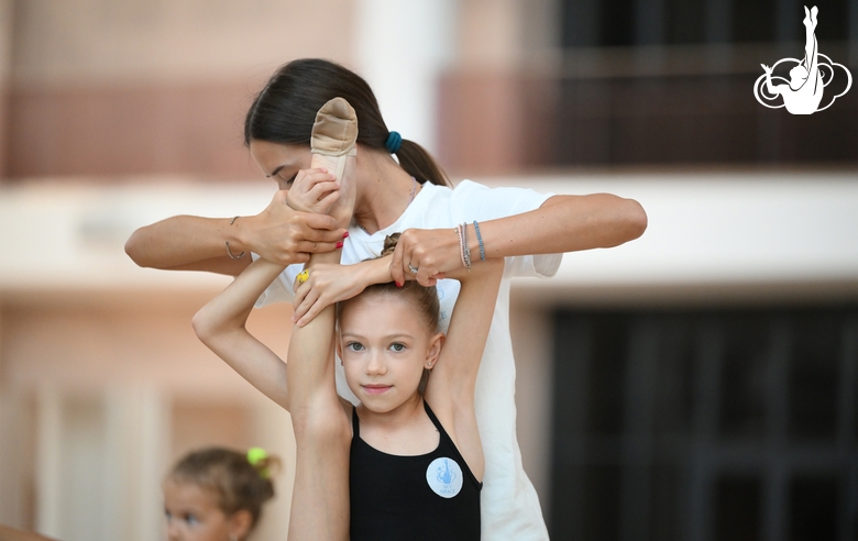 Coach Elizaveta Chernova and a young gymnast during a training