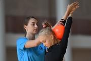 Coach Ekaterina Lots with a gymnast during practice at the training camp in the Academy