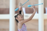 A gymnast from China during the exercise with clubs when training