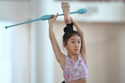 A gymnast from China during the exercise with clubs when training