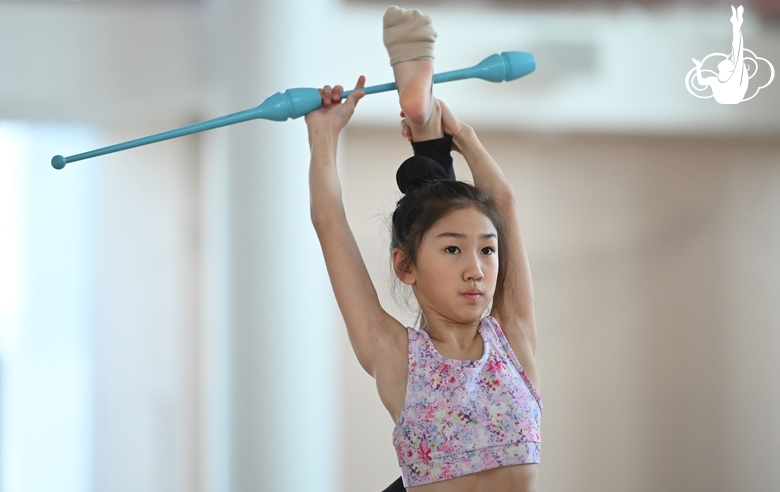 A gymnast from China during the exercise with clubs when training