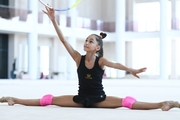 Valeria Medvedeva does a split during an exercise with a hoop