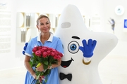 Academy Director Tatyana Kolesnikova with flowers and a mascot at the Open Doors Day