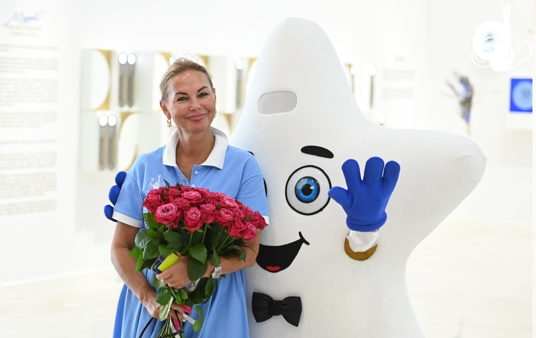 Academy Director Tatyana Kolesnikova with flowers and a mascot at the Open Doors Day