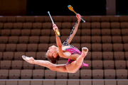 Split jump with clubs performed by a young gymnast