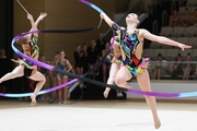 Gymnasts do an exercise with a ribbon during a group performance at the Formula of Victory competition