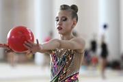 Gymnast does an exercise with a ball during training