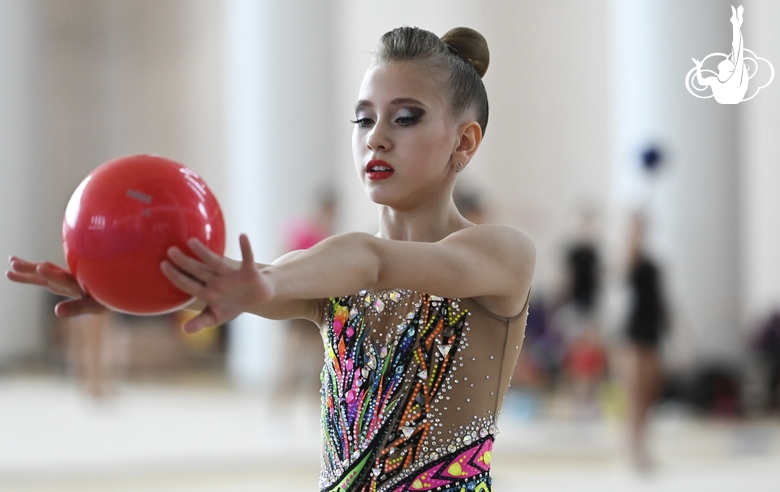 Gymnast does an exercise with a ball during training