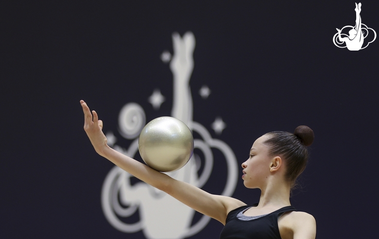 Gymnast during an exercise with a ball at floor testing