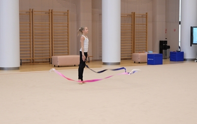 Алина Кабаева и Евгения Елисеева работают с Евой Кононовой из Тюменской области над деталями при исполнении риска в упражнении с лентой