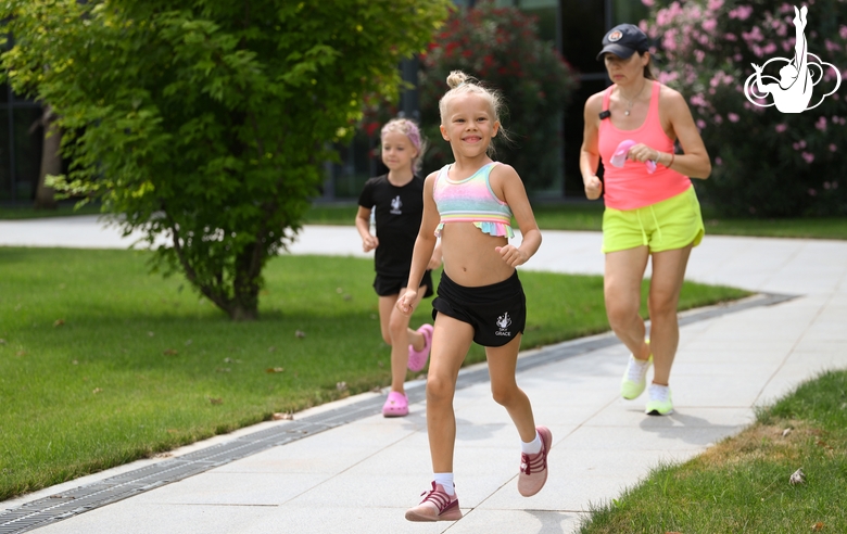 Academy coach Olesya Kovaleva and young gymnasts during a run