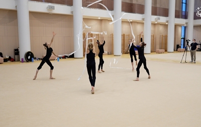 Алина Кабаева и тренер Академии Анна Усцова помогают групповичкам разобрать поддержку и переход к следующей части упражнения с пятью мячами