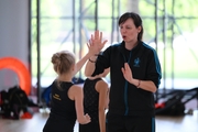 Coach Olesya Kovaleva with gymnasts during practice at the training camp in the Academy