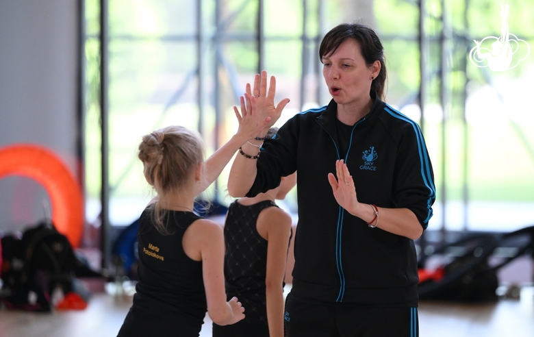 Coach Olesya Kovaleva with gymnasts during practice at the training camp in the Academy