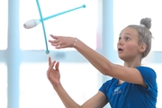 Young gymnast during an exercise with clubs