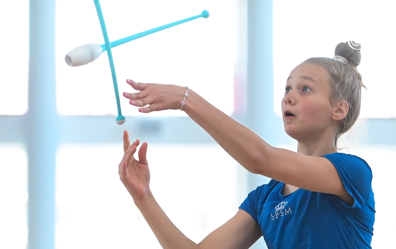 Young gymnast during an exercise with clubs