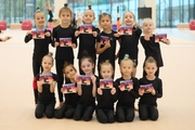 Young gymnasts hold postcards with autographs of Olympic champion Alina Kabaeva