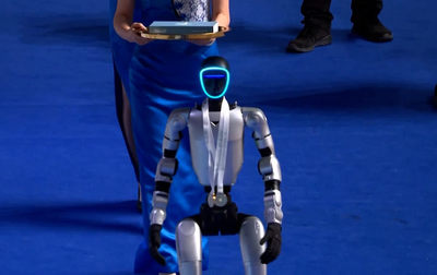 Олимпийская чемпионка Алина Кабаева и режиссер по художественной части со стороны Китая Ван Фу Ин встречают робота