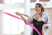 Academy coach Irina Dzyuba shows the technique of an exercise with a ribbon to Kristina Voitenko